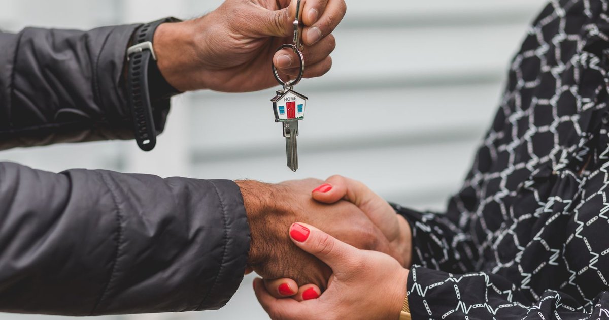 Property manager handing house keys to a new resident during a lease handoff